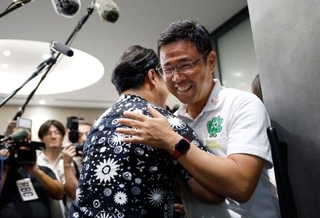 　沖縄県知事選で初当選を決め、祝福される古謝玄太氏＝１３日夜、那覇市