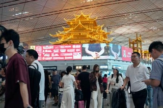 　多くの人でにぎわう北京首都国際空港の出発ロビー＝１３日（共同）