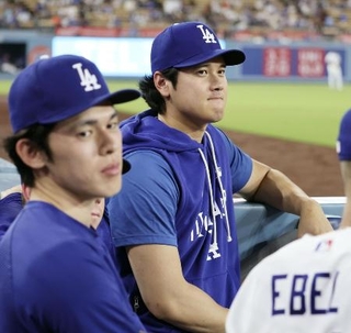 ベンチから試合を見るドジャース・大谷。左は佐々木＝９日、ロサンゼルス（共同）