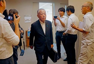 　会合が終わり会場を後にする茨城県常陸大宮市議会の秋山信夫議長＝１６日午前、常陸大宮市役所