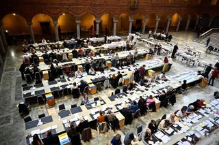 　１６日、スウェーデンのストックホルム市役所で、議会総選挙の票を数える選挙管理当局の職員ら（ＴＴ通信提供・ロイター＝共同）