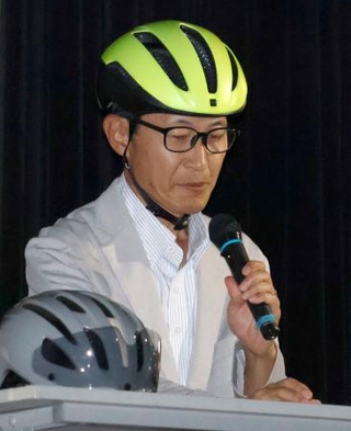 　講演で自転車乗車時のヘルメット着用を呼びかける渡辺明弘さん＝２０日午後、大阪市
