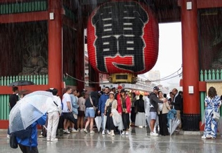 　浅草寺雷門の下で雨宿りする観光客ら＝２１日午前９時１５分、東京都台東区