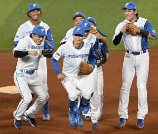 　引退試合前、チームメートに囲まれながら守備練習に向かう日本ハム・中島（手前中央）＝エスコンフィールド