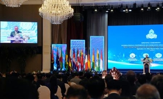 　プノンペンで開かれたオンライン詐欺対策の国際会議。右は演説するカンボジアのフン・マネット首相＝２３日（共同）