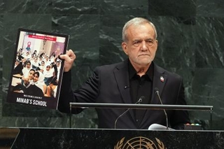 　２３日、国連総会一般討論で、写真を手に演説するイランのペゼシュキアン大統領＝米ニューヨーク（ＡＰ＝共同）