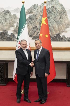 イランのアラグチ外相（左）と握手する中国の王毅外相＝５月、北京（新華社＝共同）