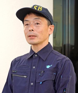 　那覇空港の近くで記者団の取材に応じる運輸安全委員会の妹尾誠之主管調査官＝２６日午前