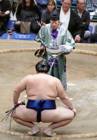 　大相撲秋場所千秋楽で、大の里（手前）に懸賞金を手渡す第３９代木村庄之助＝両国国技館
