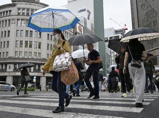 　東京・銀座を傘を差して歩く人たち。都心で連続降雨過去最長を記録した＝２９日午前
