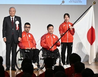 　団旗を受け取り写真に納まる（右から）旗手の中川もえ、橋本勝也、三阪洋行選手団長、森和之ＪＰＣ会長＝２９日午後、東京都中央区