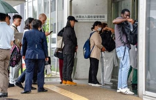 　大阪出入国在留管理局で申請のために列を作る外国人ら＝２９日、大阪市住之江区