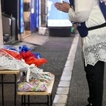 　東京・新宿の歌舞伎町で、ビル跡地に献花し手を合わせる植田安子さん＝８月３１日午後１０時ごろ