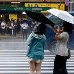 　雨の中、ＪＲ新宿駅前を歩く人たち＝７日午前
