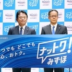 　記者会見でボードを手にする、みずほ銀行の加藤勝彦頭取（左）＝７日午前、東京都千代田区