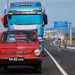 　７日、ロシアと北朝鮮を結ぶ自動車橋の開通式典で橋を通る車（タス＝共同）