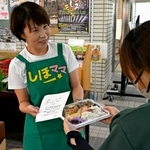 　熊本県氷川町役場でひとり親に弁当を手渡す柳原志保さん＝８月