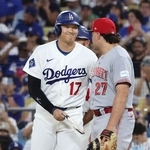 　レッズ戦の７回、四球で出塁し、一塁手スチュワート（右）と笑顔で言葉を交わすドジャース・大谷＝ロサンゼルス（共同）