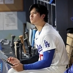 　レッズ戦の８回、ベンチでタブレットを手にするドジャース・大谷＝ロサンゼルス（共同）