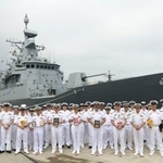 　寄港したニュージーランド海軍の哨戒艦テ・マナと写真に納まる同国海軍と海上自衛隊の関係者＝８日午前、海上自衛隊横須賀基地