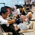　大雨の影響による帰宅困難者のために開放された名古屋駅近くの商業施設で座り込む人たち＝８日夜