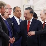 　９日、ベトナムのトー・ラム国家主席（右から２人目）にロシア政権幹部を紹介するプーチン大統領（右端）＝モスクワ（タス＝共同）