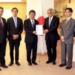　茂木外相（中央左）に提言を渡す県公一郎早大名誉教授（同右）ら＝１０日午後、外務省