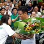　沖縄県知事選で初当選を決め、花束を受け取る古謝玄太氏＝１３日夜、那覇市