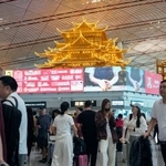 　多くの人でにぎわう北京首都国際空港の出発ロビー＝１３日（共同）