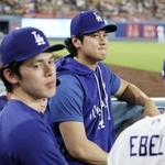 ベンチから試合を見るドジャース・大谷。左は佐々木＝９日、ロサンゼルス（共同）