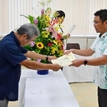 　沖縄県知事選で初当選し、当選証書を受け取る古謝玄太氏（右）＝１６日午前、沖縄県庁