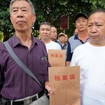 　訴状の入った袋を持ち、高級人民法院に向かう日中戦争時の強制連行の中国人被害者遺族ら＝１６日、中国河北省石家荘市（共同）