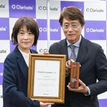 　クラリベイト関係者から賞状とトロフィーを受け取った九州大の安達千波矢主幹教授（右）＝１７日午後、東京都港区