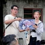 　紙芝居を手に取って参加者らに説明する吉村大作さん（左）＝２０日、台北市（共同）