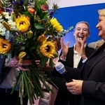 　ベルリン特別市の議会選で投票が終わり、出口調査の結果を受けて花束を贈られる候補者（右）＝２０日、ベルリン（ロイター＝共同）
