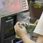 　スーパーでレジに通される商品＝７月、東京都内