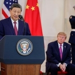 　ワシントンのホワイトハウスで開かれた式典であいさつする中国の習近平国家主席。奥はトランプ米大統領＝２４日（ロイター＝共同）