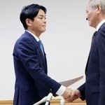 　横浜市長選への出馬要請を受け、握手を交わす山中竹春前市長（左）＝２５日午後、横浜市