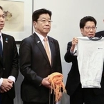 　訪米に持参した横田めぐみさんの体操服を示し、報道陣の取材に応じる拉致被害者家族会代表の横田拓也さん（右から２人目）ら＝２５日午後、羽田空港（代表撮影）