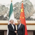 イランのアラグチ外相（左）と握手する中国の王毅外相＝５月、北京（新華社＝共同）