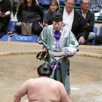 　大相撲秋場所千秋楽で、大の里（手前）に懸賞金を手渡す第３９代木村庄之助＝両国国技館