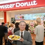 　ミスタードーナツの上海店前で商品を手にするダスキンの大久保裕行社長＝２８日（共同）