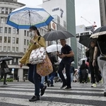 　東京・銀座を傘を差して歩く人たち。都心で連続降雨過去最長を記録した＝２９日午前