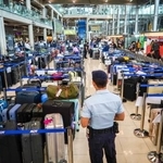 　タイ・バンコク近郊のスワンナプーム国際空港で、大量の荷物のそばに立つ警備員＝２９日（ロイター＝共同）