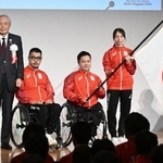 　団旗を受け取り写真に納まる（右から）旗手の中川もえ、橋本勝也、三阪洋行選手団長、森和之ＪＰＣ会長＝２９日午後、東京都中央区