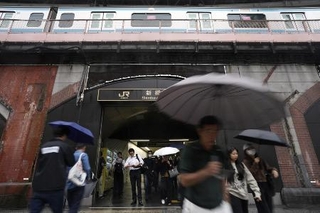 　傘を差して東京・新橋駅前を歩く人たち＝９月３０日
