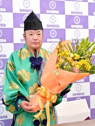 　引退記者会見で花束を手にする第３９代木村庄之助＝５日、両国国技館