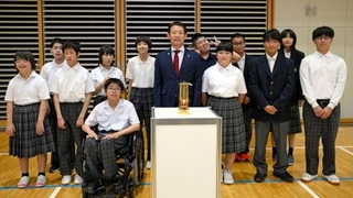 　アジアパラ大会聖火リレーの火がともされたランタンと写真に納まる生徒ら＝６日午後、愛知県西尾市
