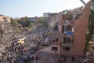 　ロシアのミサイル攻撃を受けたウクライナ北部チェルニヒウ州プリルキの集合住宅でがれきを片付ける地元住民ら＝７日（ＡＰ＝共同）