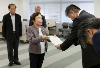 　富山市役所で中田祐一企画管理部次長（右）に要請書を手渡す市民団体の広瀬妙子代表委員＝８日午後